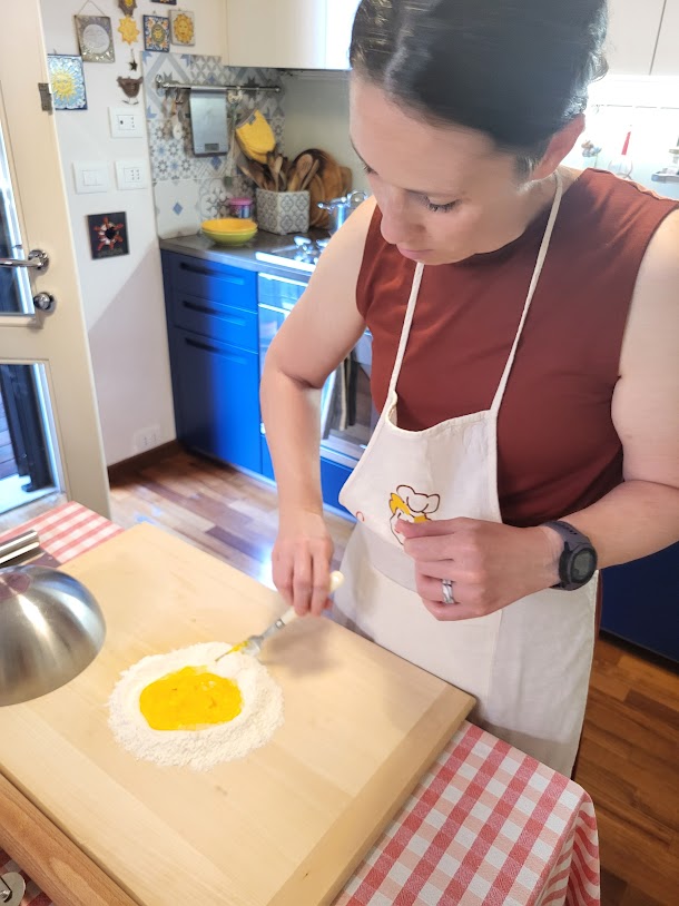 Making pasta with flour with a well for eggs, mixing with a fork