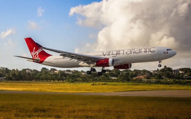 Photo of a Virgin Atlantic plane with white body and red and white signage for the logo.