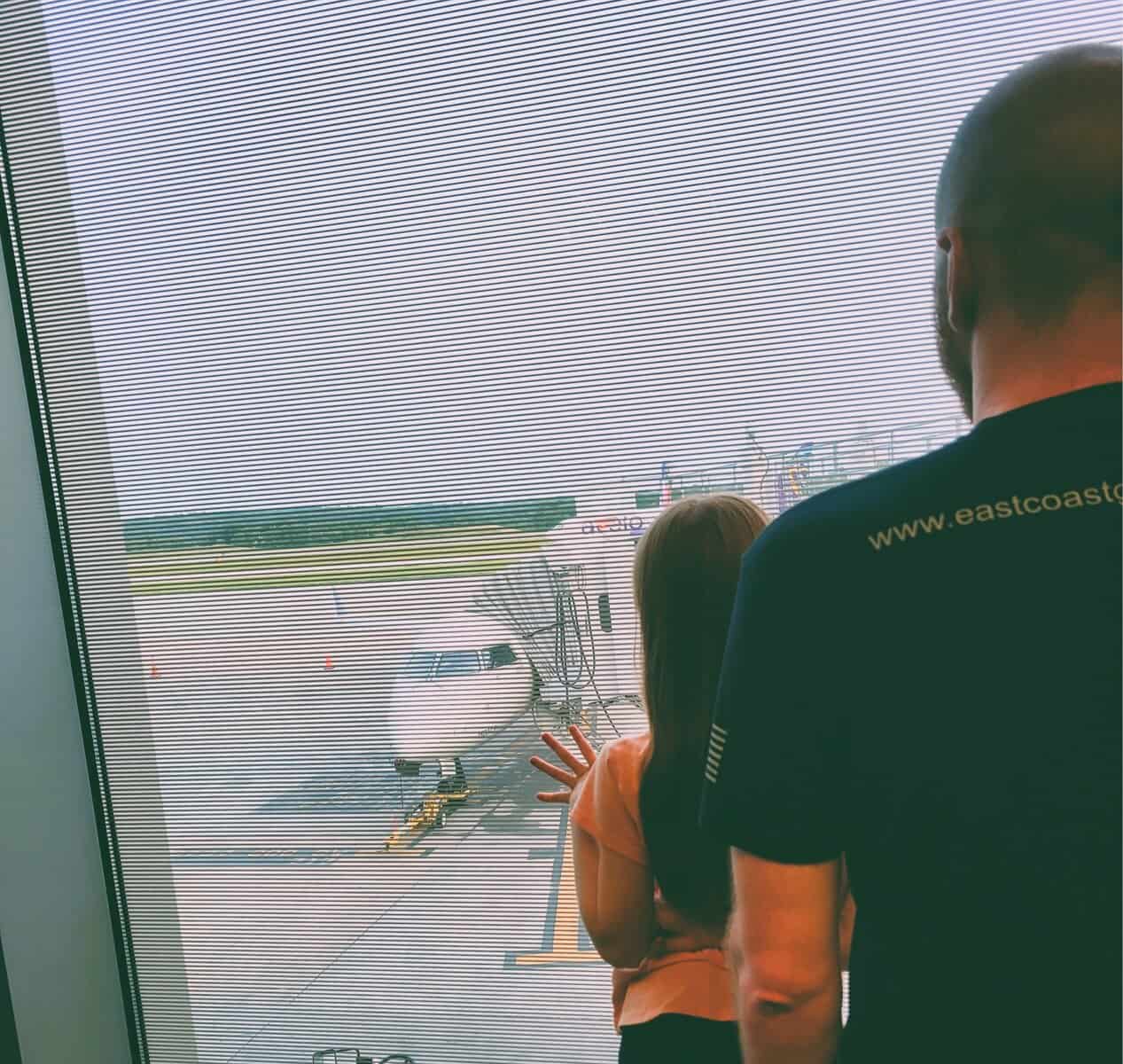 girl-dad-at-airport-watching-plane-from-window