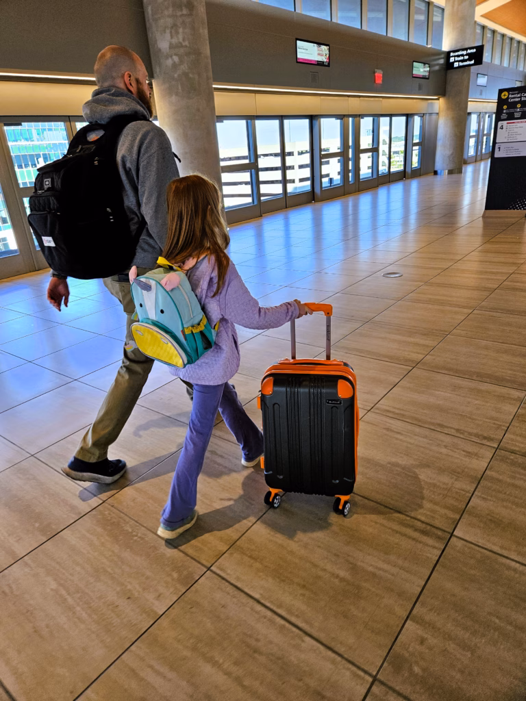 Man and girl walking through the airport