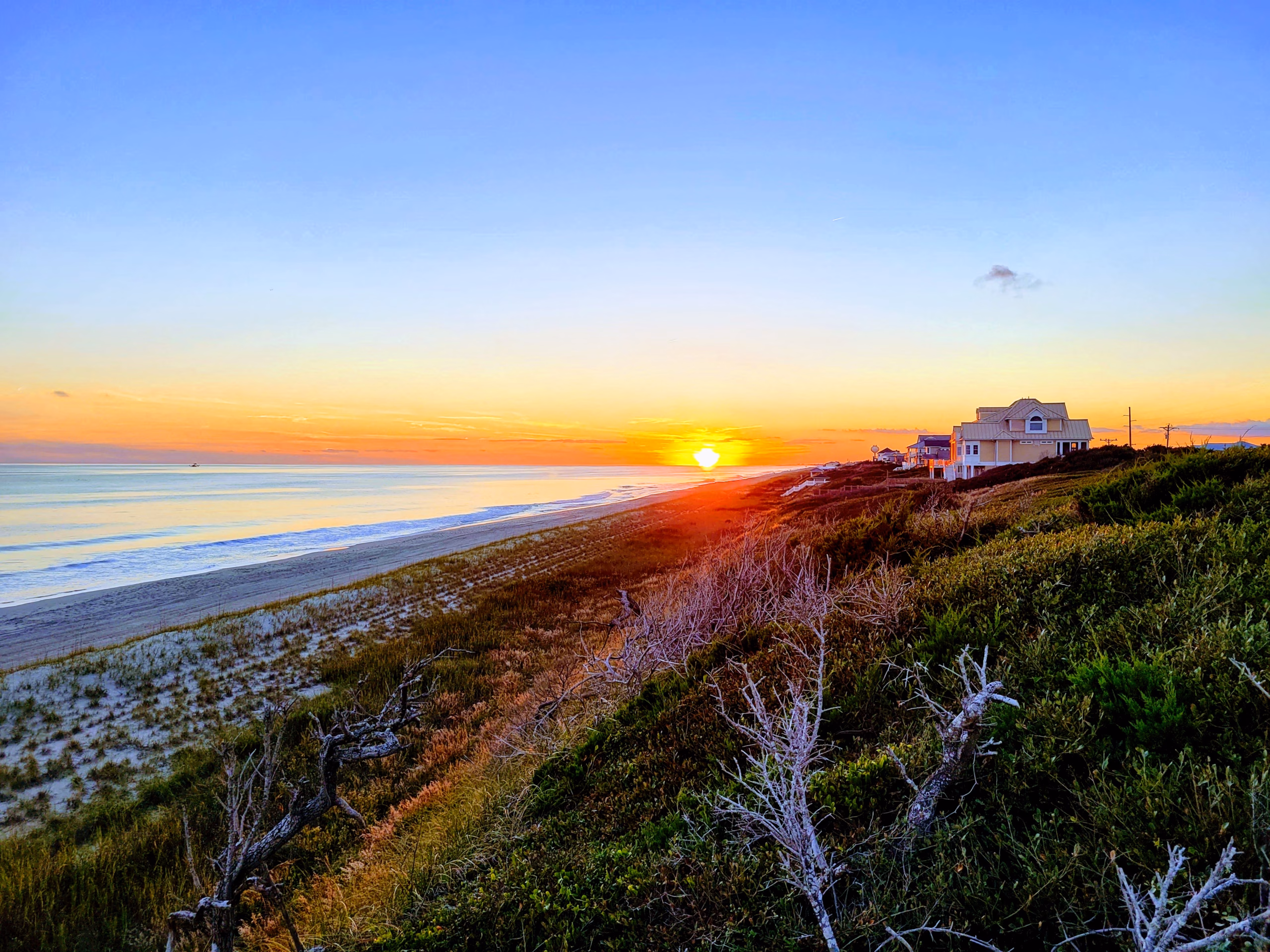 Indian beach view of the sun, a vacation home and the ocean.