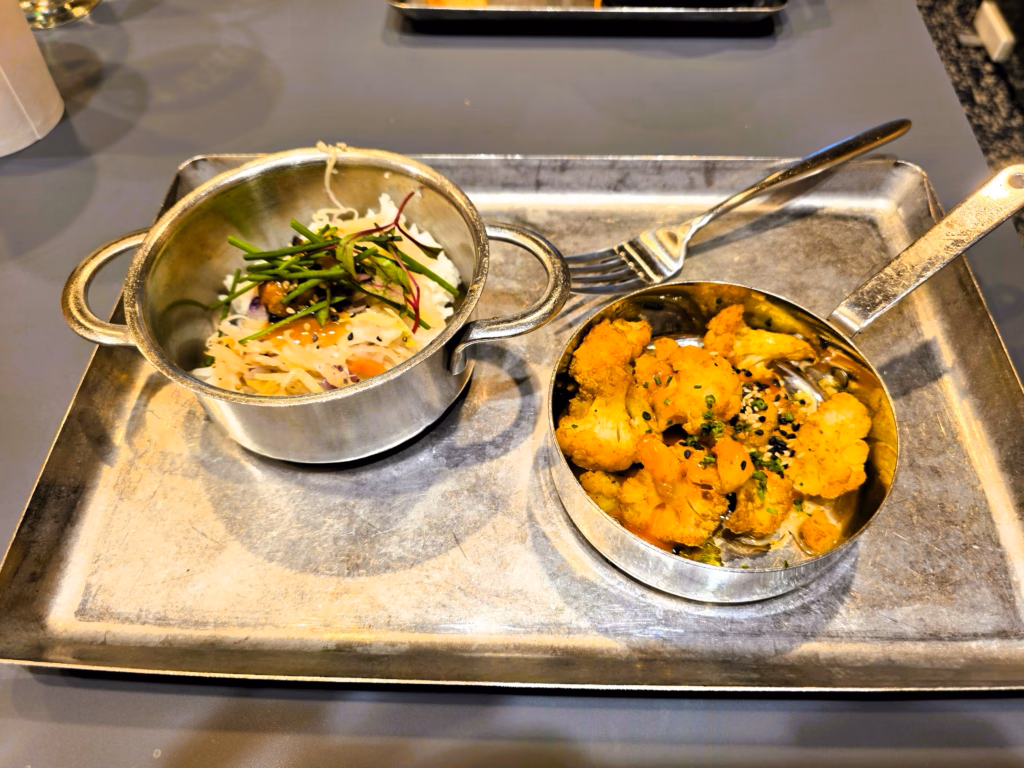 Tray of tamari braised pork belly and curried cauliflower at Capital One Lounge Denver