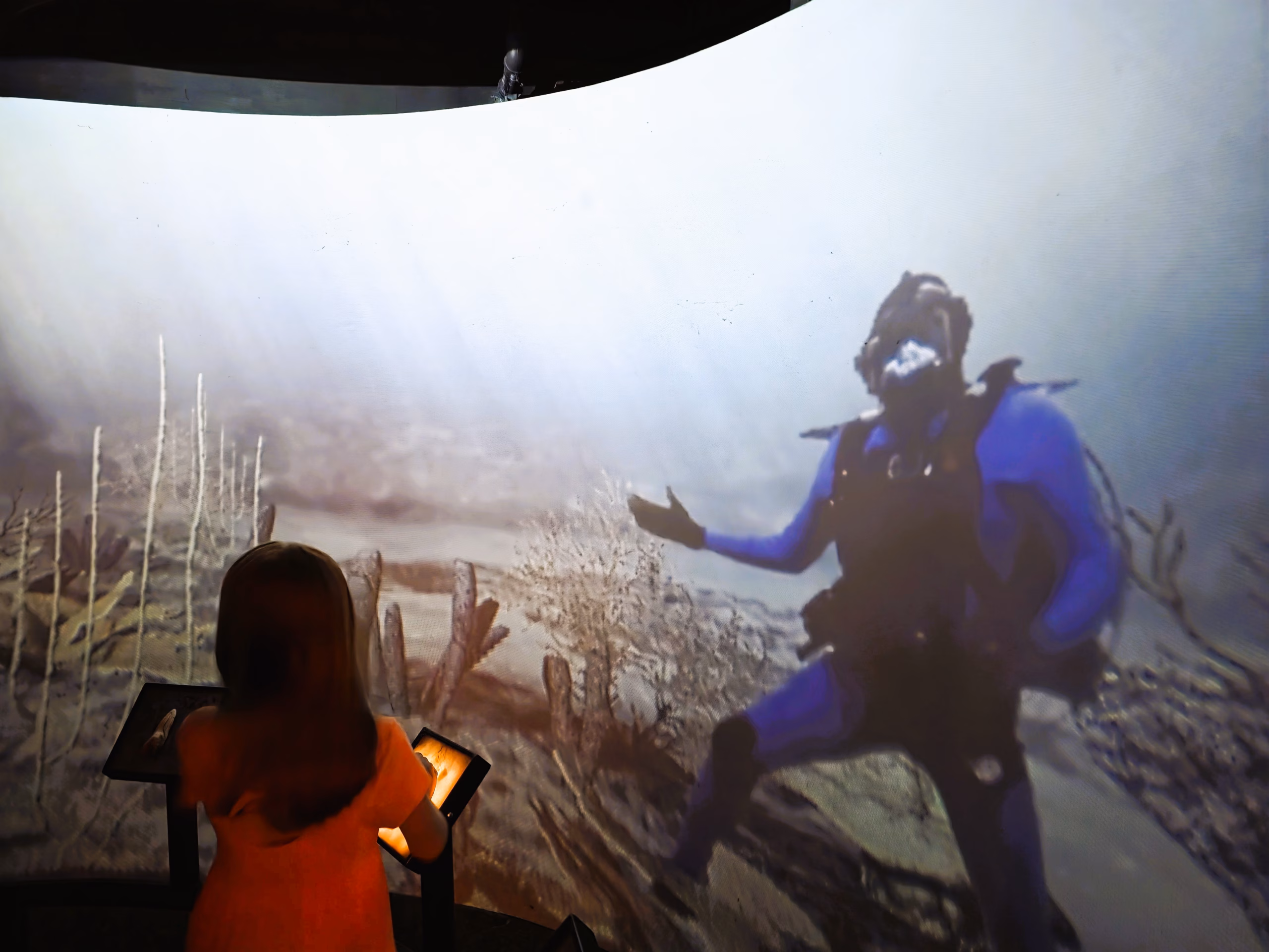 Child watching an interactive underwater video exhibit at the North Carolina Aquarium at Fort Fisher