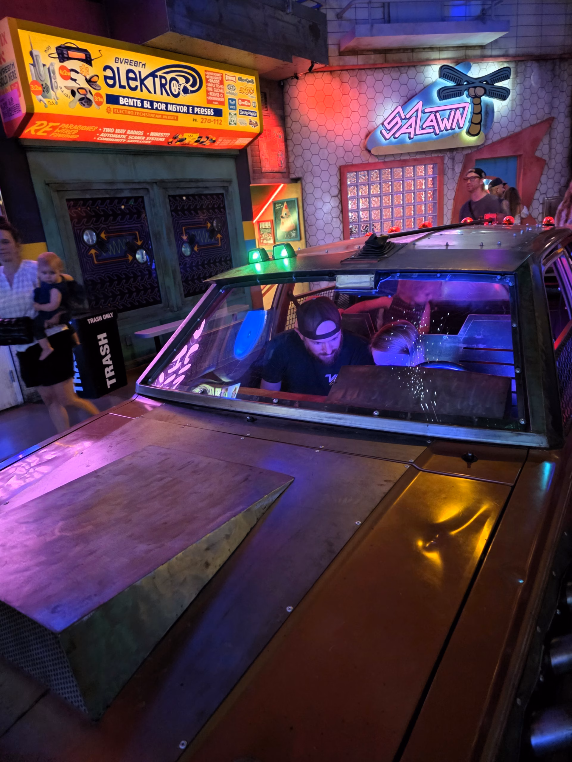 dad and child sitting in a car as part of the meow wolf interactive 4 worlds exhibits in denver